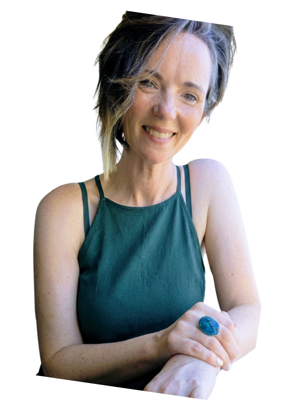 Corenia Murphy — smiling warmly with short silver-streaked hair, arms gently crossed, wearing a teal top